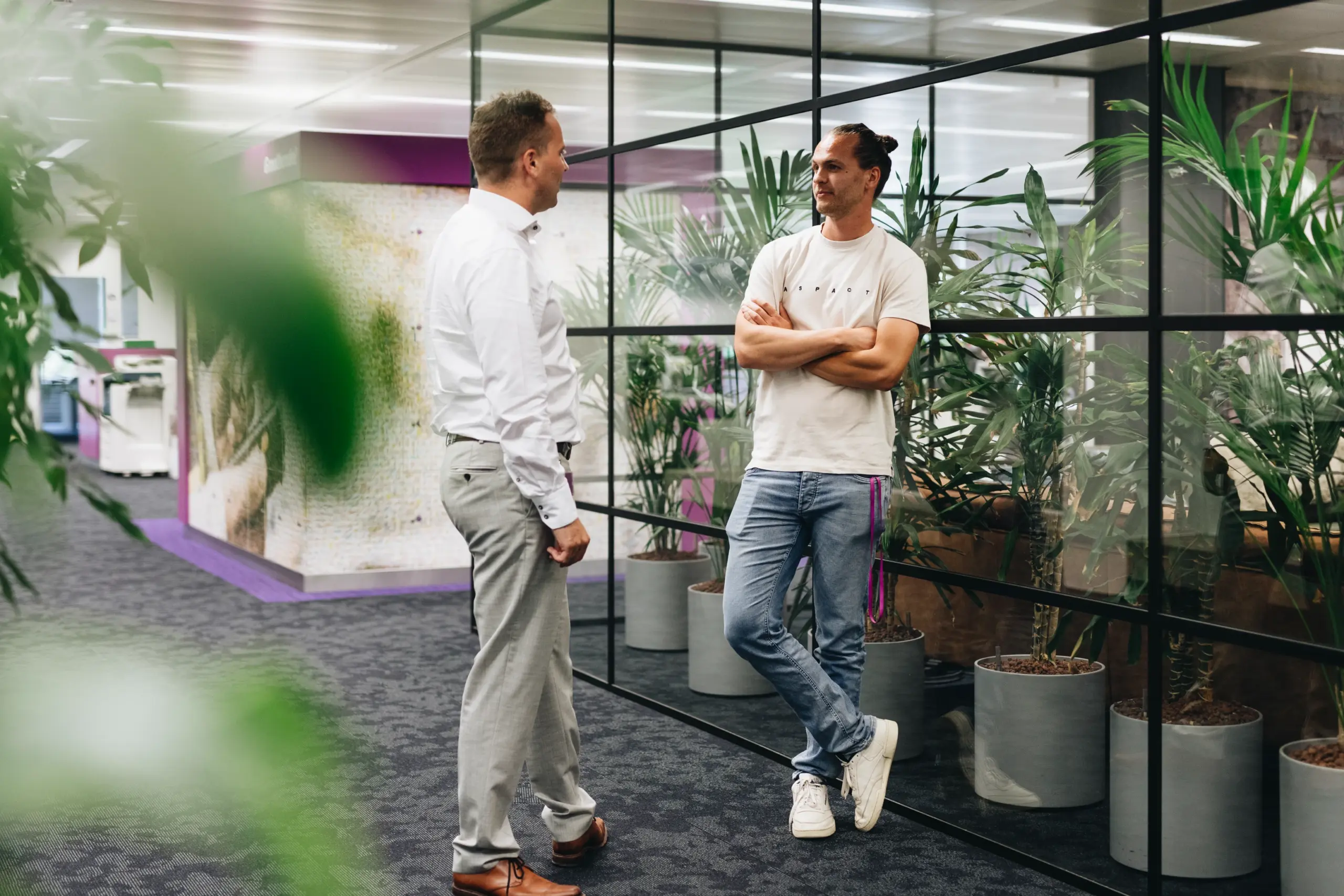 Employees work together in an open office environment that supports hybrid work and digital collaboration.