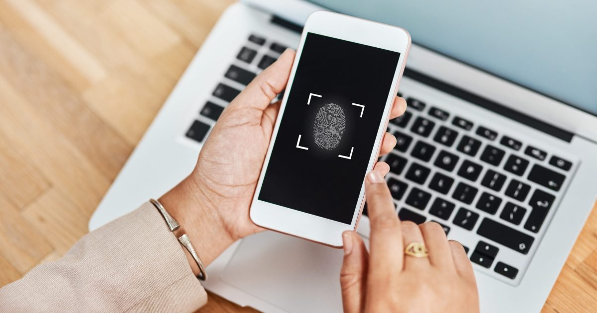 Shot of an unrecognizable businesswoman using a cellphone and laptop in her office.