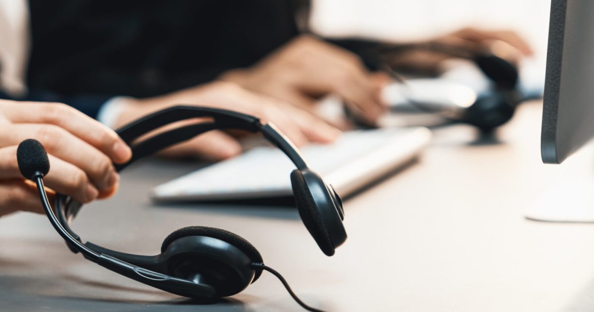 Panorama,Focus,Hand,Holding,Headset,On,Call,Center,Workspace,Desk