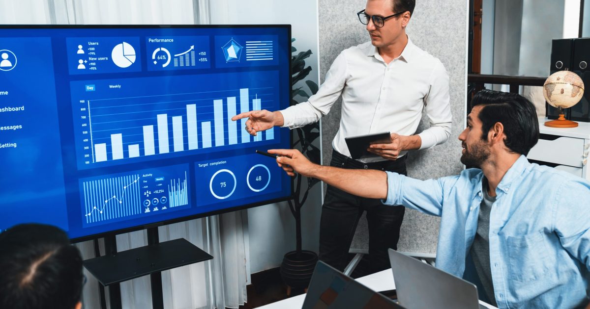 Presentation,In,Office,Or,Meeting,Room,With,Analyst,Team,Utilizing